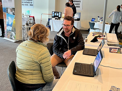 Josh Fielding from FRDC answering questions from a member of the public interested in Atlantic Salmon science 