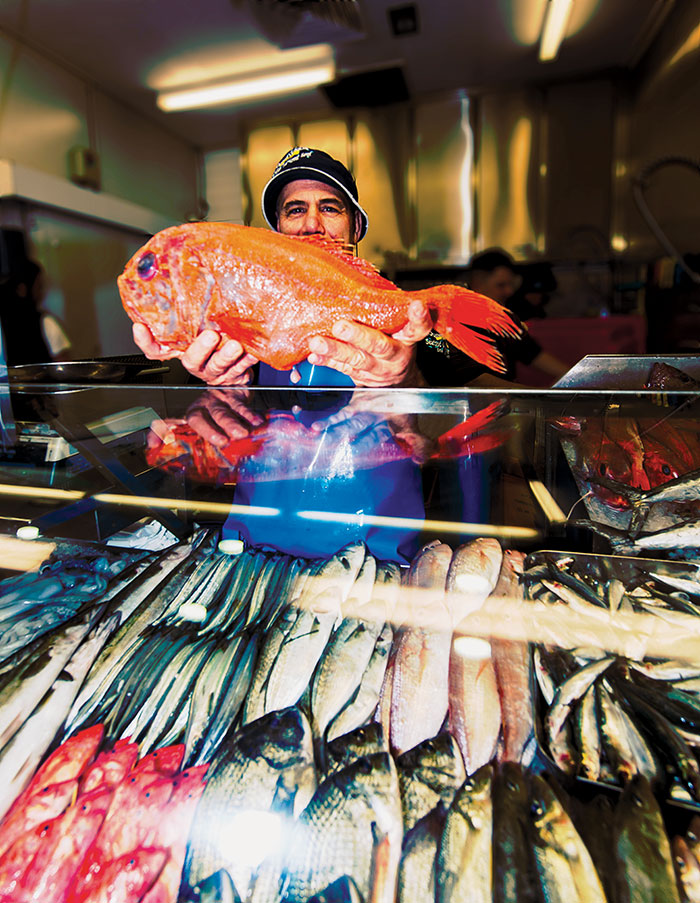 Photo of John Yiannatzis, stallholder at Seafood Oyster Spot, Queen Victoria Market, holding an Orange Roughy