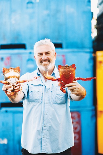 Photo of Jason Simpson from Fraser Isle Spanner Crabs holding freshly caught crab.