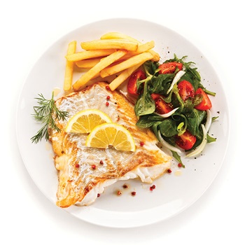 Photo of fish, lemon wedges, salad and chips on a white plate