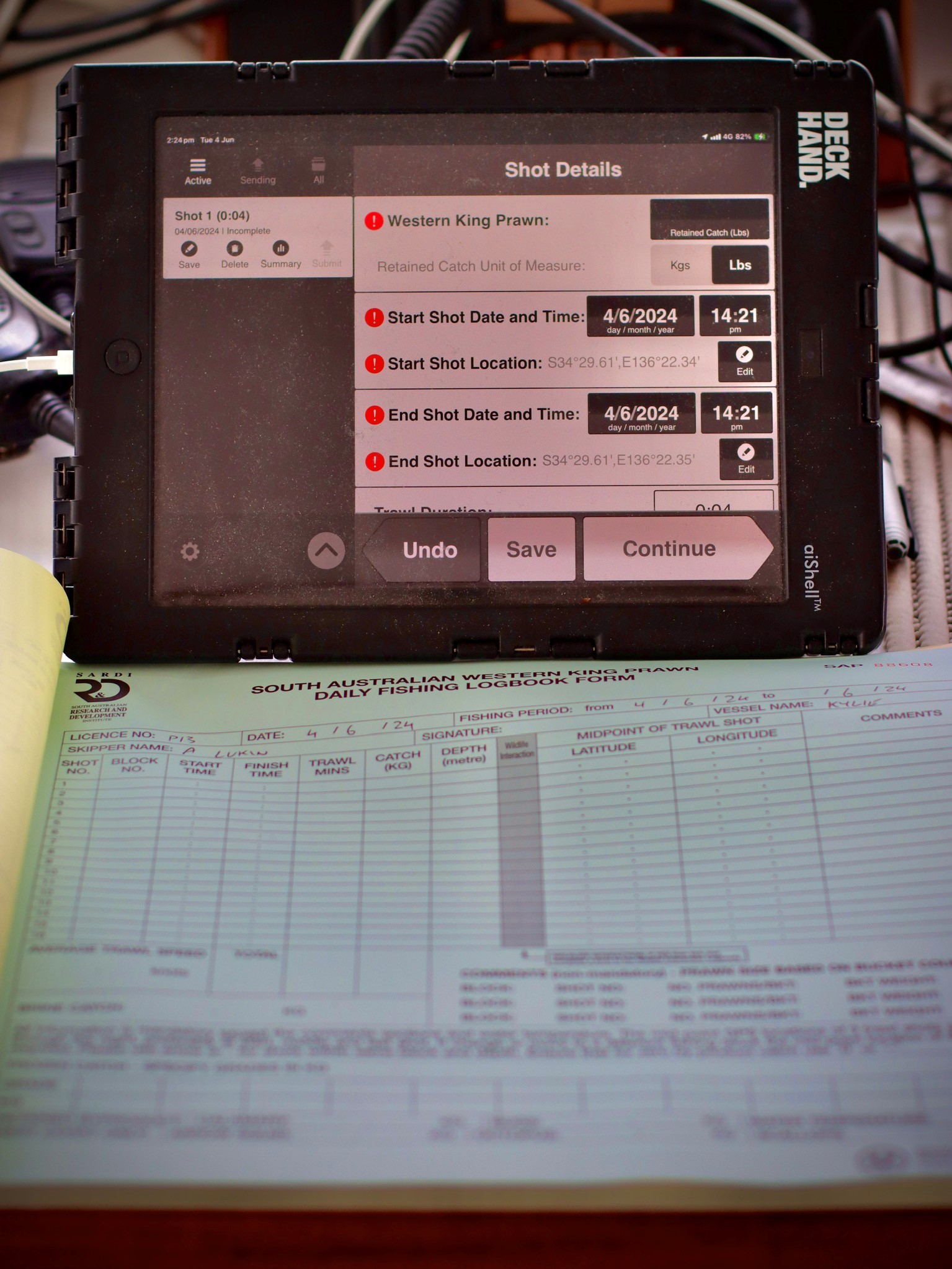 Pictured is deckhand above, with the logbook shown being filled out below on table