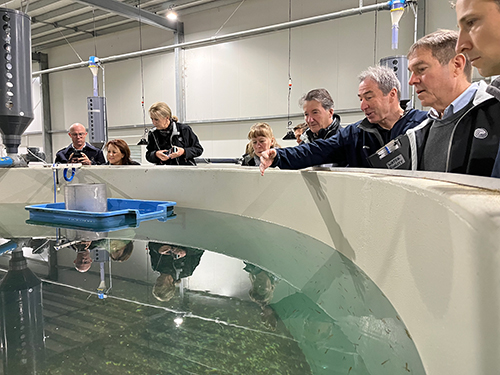 A group of FRDC Board members and support staff looking at a water tank