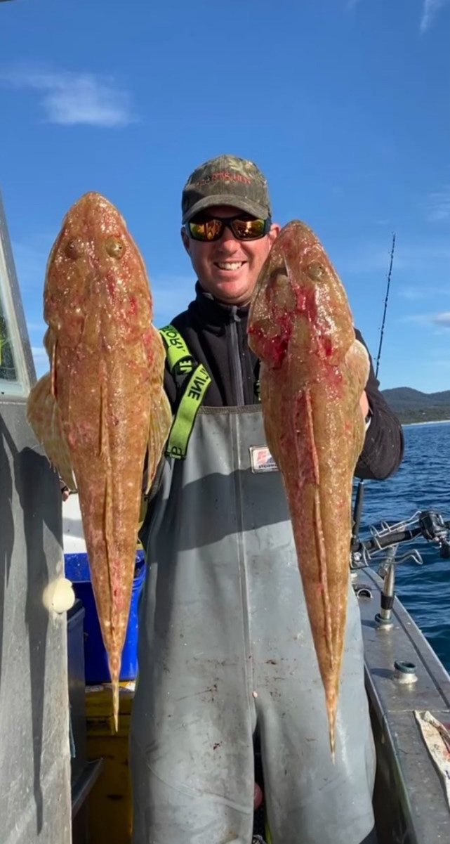 A person holding two fish