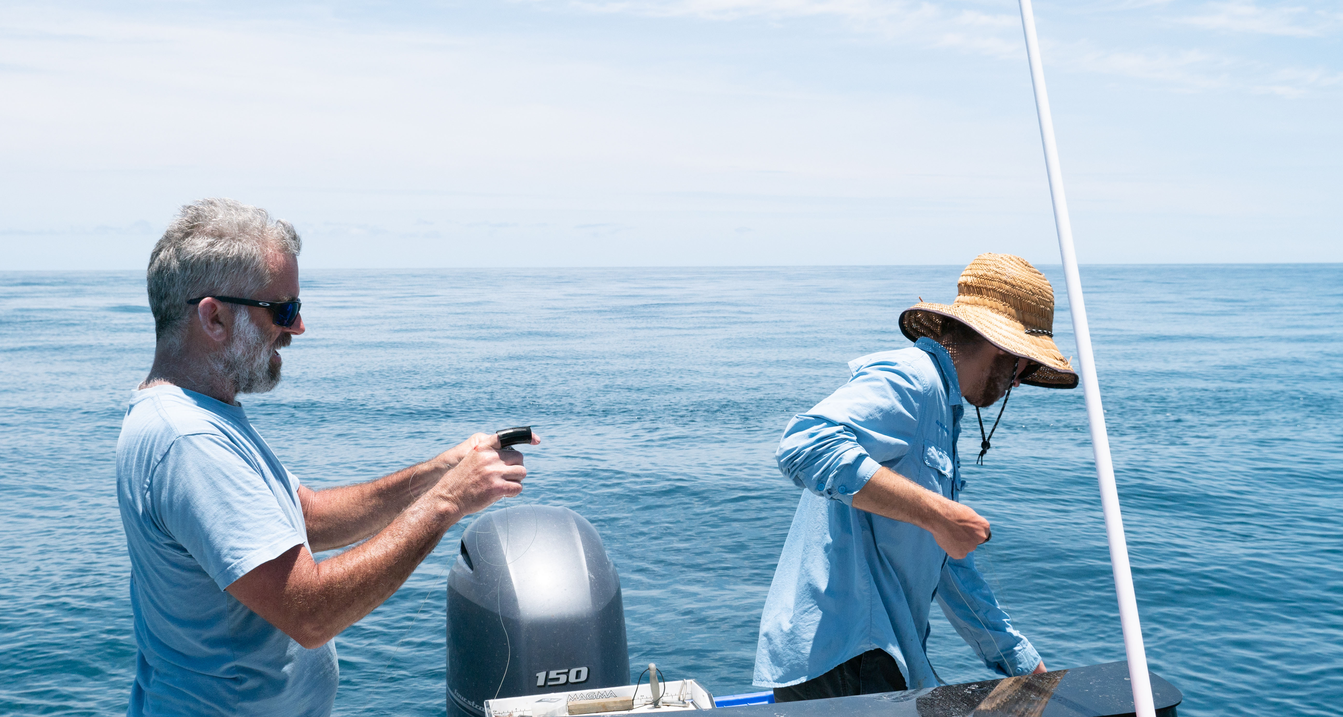 The Tobins (two men) line-fishing on boat in Queensland water
