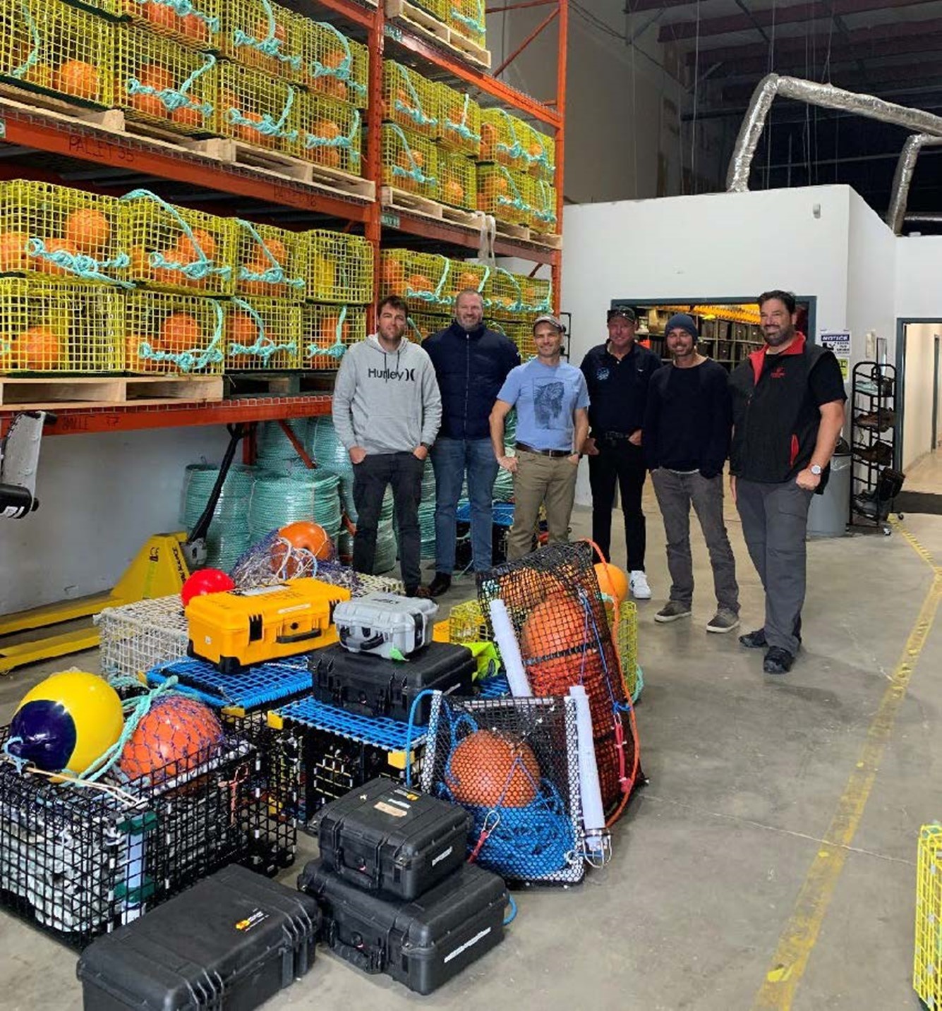 Trap fishers standing in front of ropeless fishing gear used in nova scotia