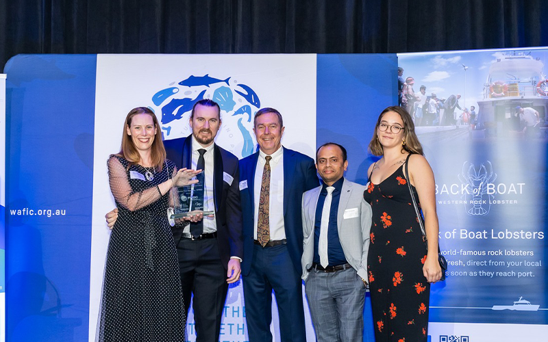 Western Australia winning RD&E Award on stage, shaking hands with FRDC Board member Alex Ogg