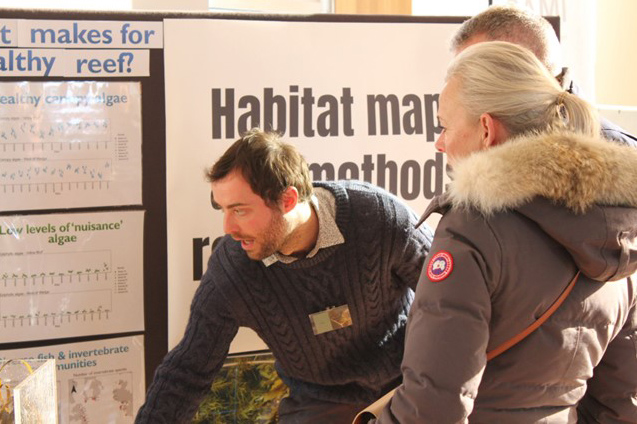 A group of people looking at a poster